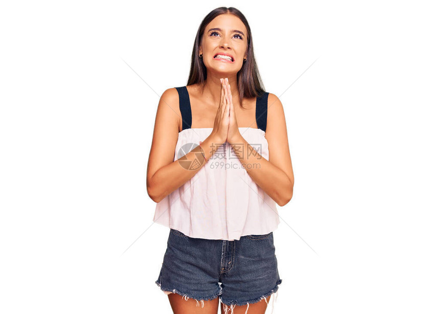 身着便衣的年轻西班牙妇女乞讨双手祷告图片