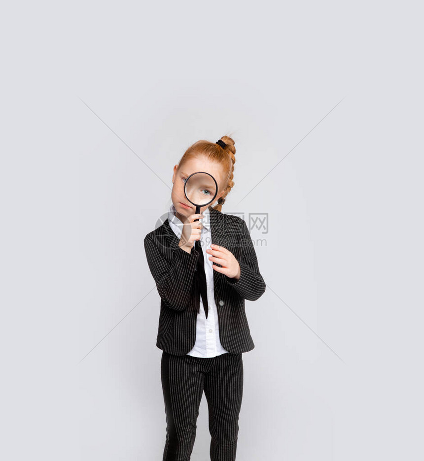 带放大镜的西装的年轻女孩概念照片表示寻找问图片