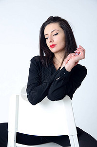 来自波兰的勇敢自信的女人年轻女在演播室里摆着白椅子背景图片