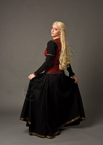 穿着红色和黑色中世纪服装的金发女孩的全长肖像图片