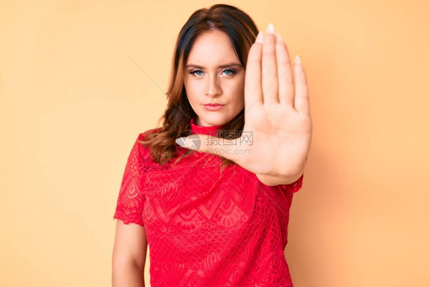 年轻漂亮的白种女人穿着休闲服做停止用手掌脸上带着消极和严肃的图片