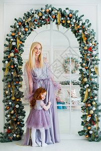 母亲和小红发女儿站在古典室内图片