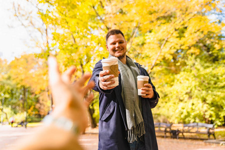 男人带咖啡来朋友喝酒去户外玩秋天城市公图片