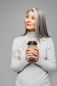 穿着灰色头发的身高海龟的亚洲妇女拿着咖啡在图片