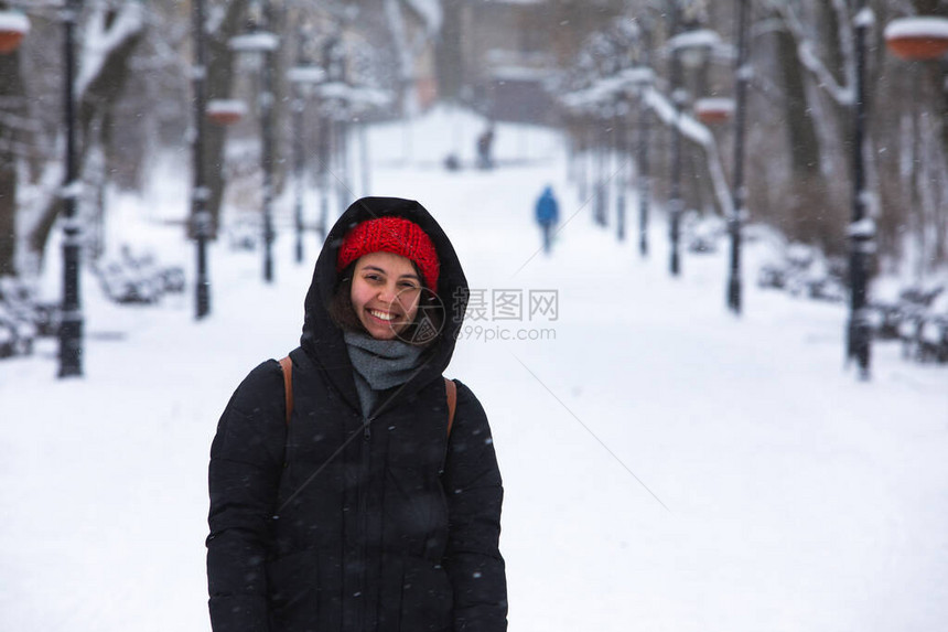 在城市积雪公园的冬季装扮中微笑图片