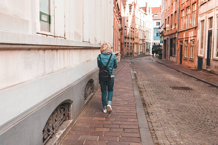 一名妇女走在比利时布鲁日背景图片