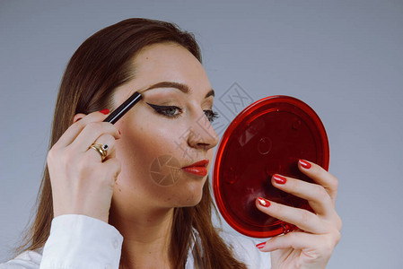 美女模特少女照镜子涂抹睫毛膏化妆美丽的图片