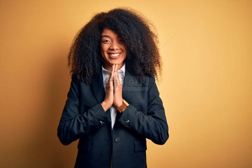 身穿优雅外套的年轻美籍非洲女商人用双手祈祷一起祈求宽恕微笑着满怀信心地请求原谅图片