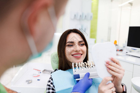 牙科办公室的病人拿着一个有牙齿阴影的调色板图片