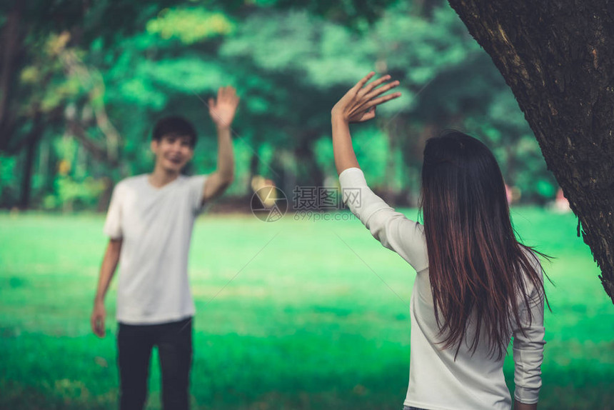 年轻人男人和女人在公园里挥手打招呼或告别图片