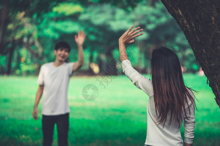 年轻人男人和女人在公园里挥手打招呼或告别图片