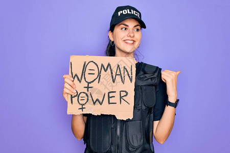 身穿安全防弹背心制服的女警手拿着女权抗议纸板图片