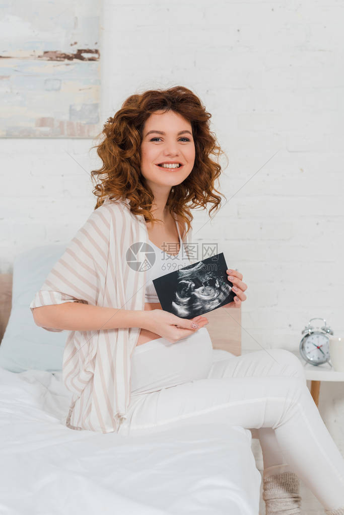 美丽的孕妇在卧室内对婴儿进行超声波扫描时微图片