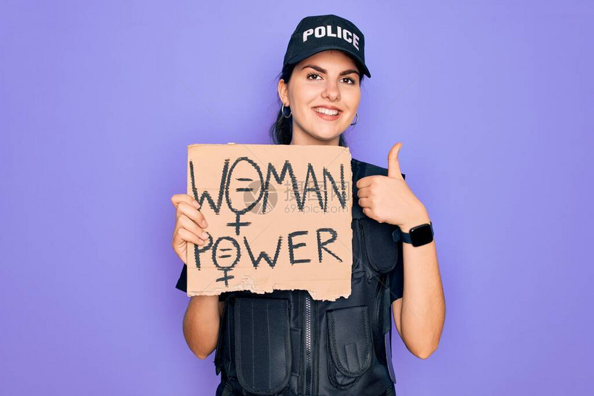 身穿安全防弹背心制服的女警手拿着女权抗议纸板图片