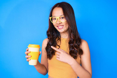 身戴眼镜的年轻女孩拿着一杯咖啡图片