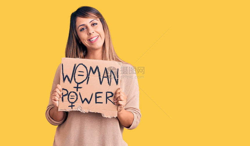 年轻漂亮的女人举着女人的力量横幅图片