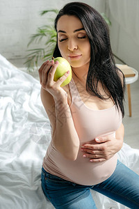 睡在床上时拿着苹果的怀孕图片