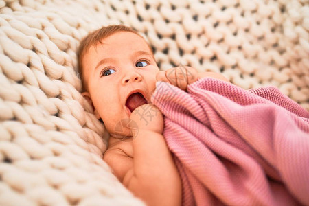在家里沙发上躺在毯子上躺着的可爱婴儿图片