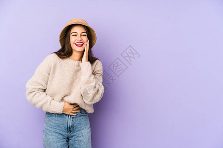 与紫色背景隔绝的年轻caucasian女子笑得开心图片