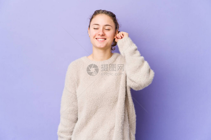 紫色背景的年轻caucasian女人庆祝胜利和热情图片