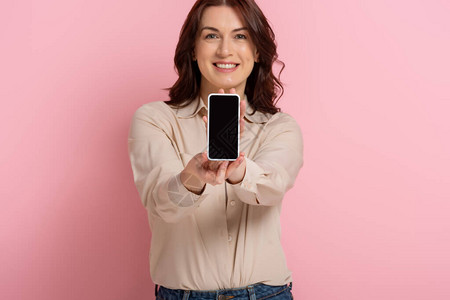 有选择地关注微笑的女士展示智能手机背景图片