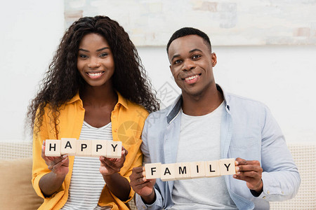 非洲美籍男子和黑发女人拿着带快乐家庭字图片
