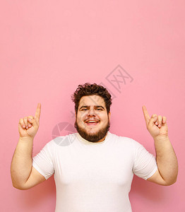身穿白色T恤卷发和胡须的快乐胖子的垂直肖像被粉红色背景隔开背景图片