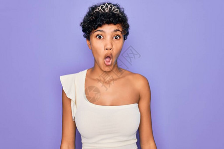 年轻漂亮的非洲裔美国黑人女戴着紫色背景的头饰图片