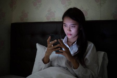 晚上在床上使用手机的亚洲女人图片
