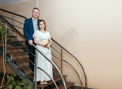 一对情侣站在地主大厅的楼梯上结婚时图片