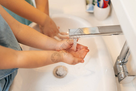 在水龙头下洗手用肥皂洗手图片