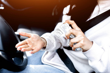 女在汽车里使用手消毒剂图片