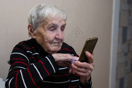 老年妇女养恤金领取人打智能手机图片