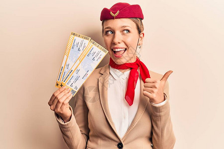 身穿空姐制服的金发美女拿着登机牌图片