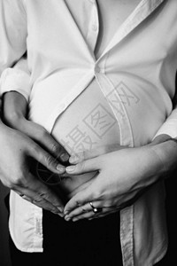 孕妇和男人在肚子上握手时图片