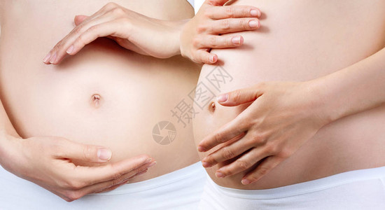 怀孕初期怀有腹部的孕妇在白内裤穿白色内衣包扎在一图片