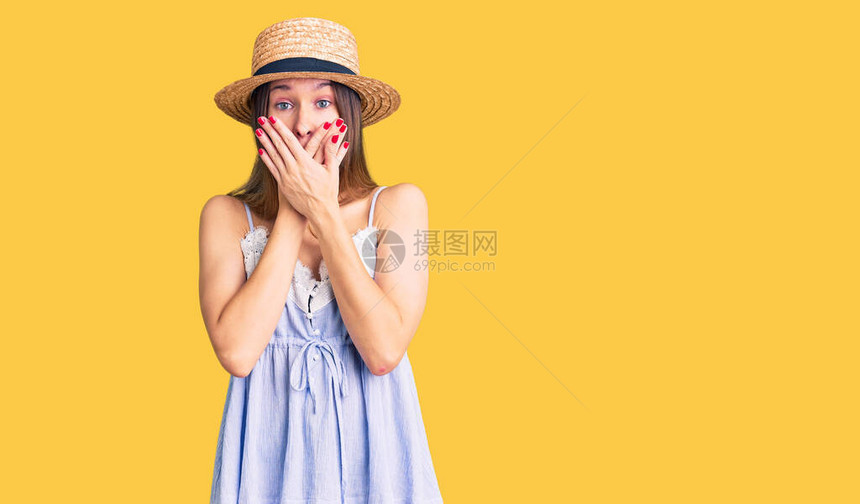 戴着暑假帽子的美丽的黑发年轻女子以错误之手用双手遮图片