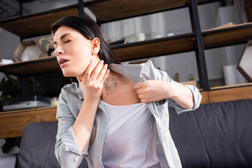 闭着眼睛接触脖子的哮喘妇女图片