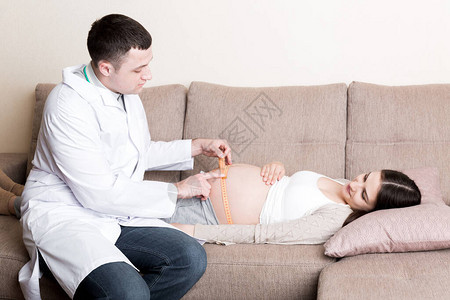 医生正在测量家中怀孕病人肚子的增长图片
