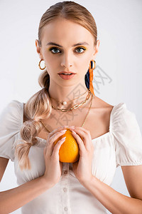 优雅的金发女子装扮成橙色背景图片
