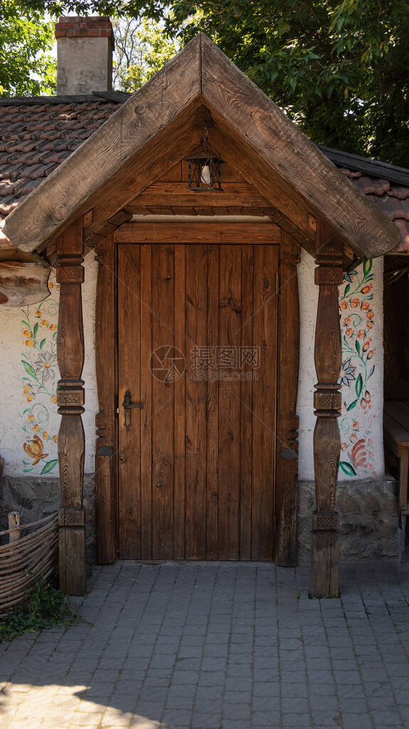 带遮阳篷和横梁的木制旧门童话屋的入口民族概念图片