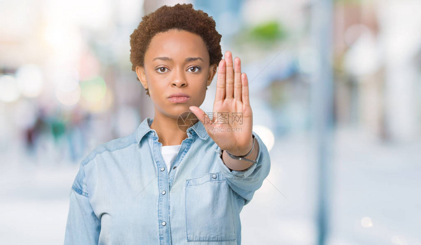 年轻美丽的非洲裔美国女人在孤立的背景下停止用手掌脸上带着消极和严肃的图片