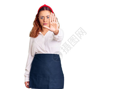 身着女服务员围裙的年轻拉廷妇女停止用手掌图片
