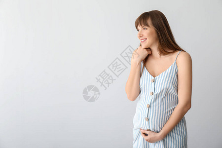 浅色背景的年轻孕妇图片