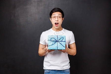 庆祝假期和生活方式的概念惊讶的快乐亚洲b日小伙收到可爱的包装礼物图片