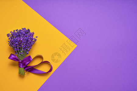 一堆黄紫色背景上的新鲜薰衣草紫罗兰花卉贺卡与文本的地方顶视背景图片