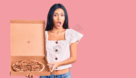 年轻美丽的拉丁女孩拿着送外卖的披萨盒图片