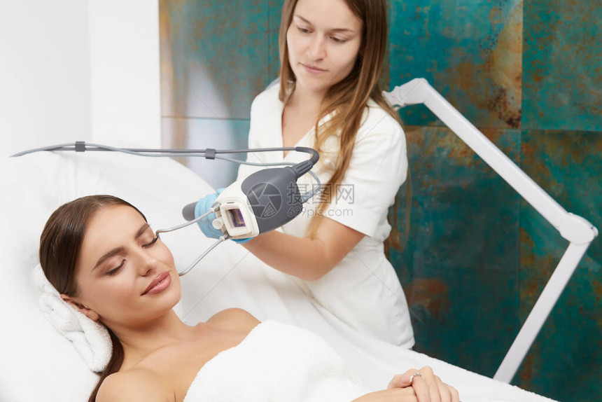 美容师用激光做美容手术的漂亮女人图片