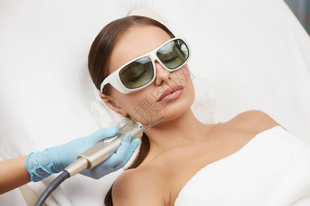 小女人戴防护眼镜下巴接受激光手术图片