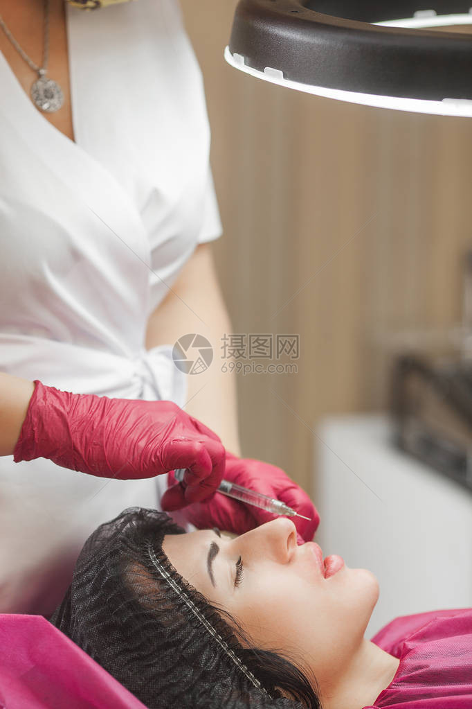 美容师制作程序皮肤科医生正在注射透明质酸仍然关闭嘴唇注射唇部加强程序图片